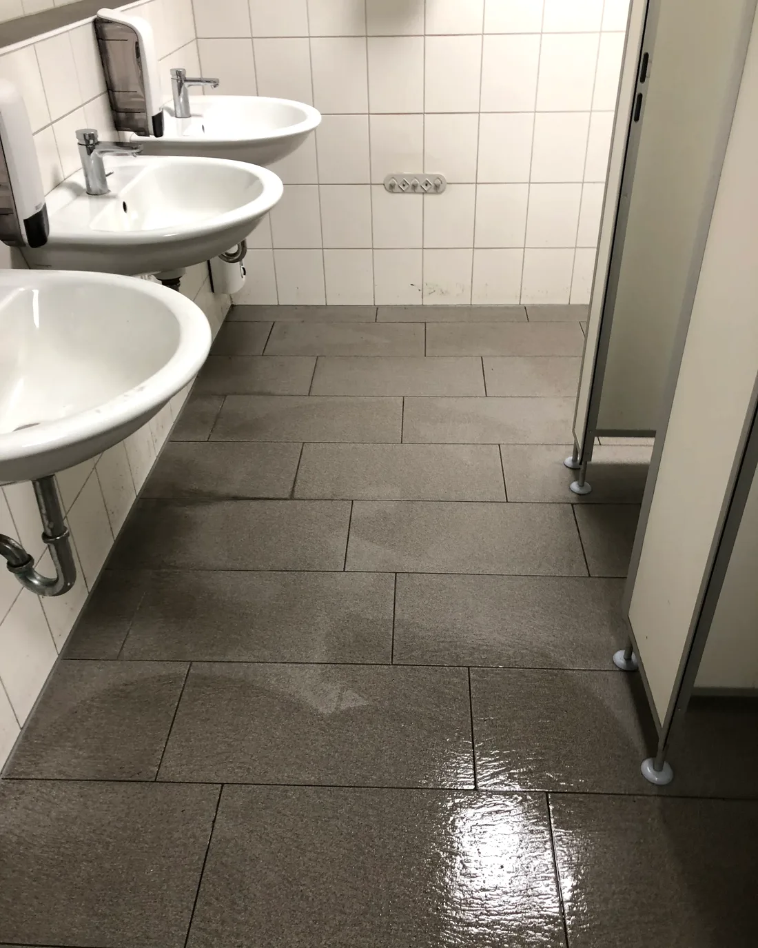 Frisch gewischter Sanitärbereich mit drei Waschbecken in einem Kundenobjekt