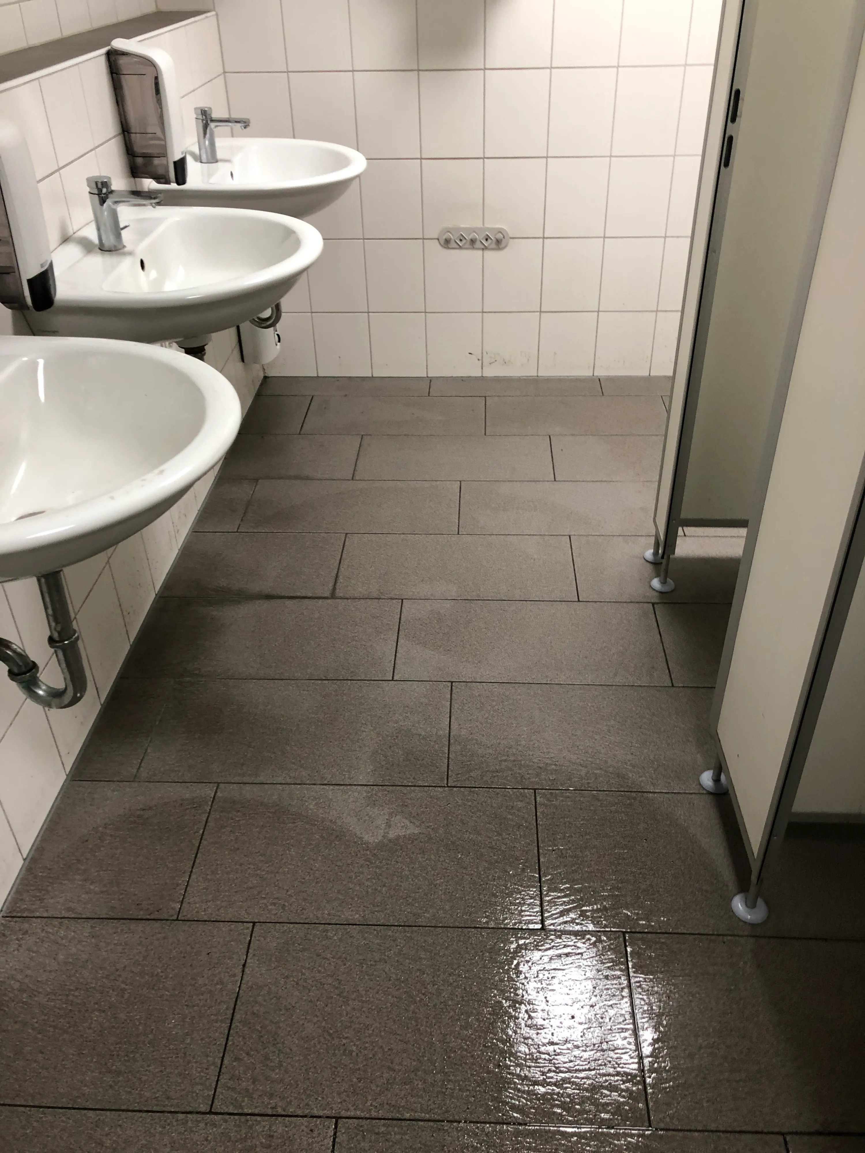 Frisch gewischter Fliesenboden in einer Sanitäranlage in Soest